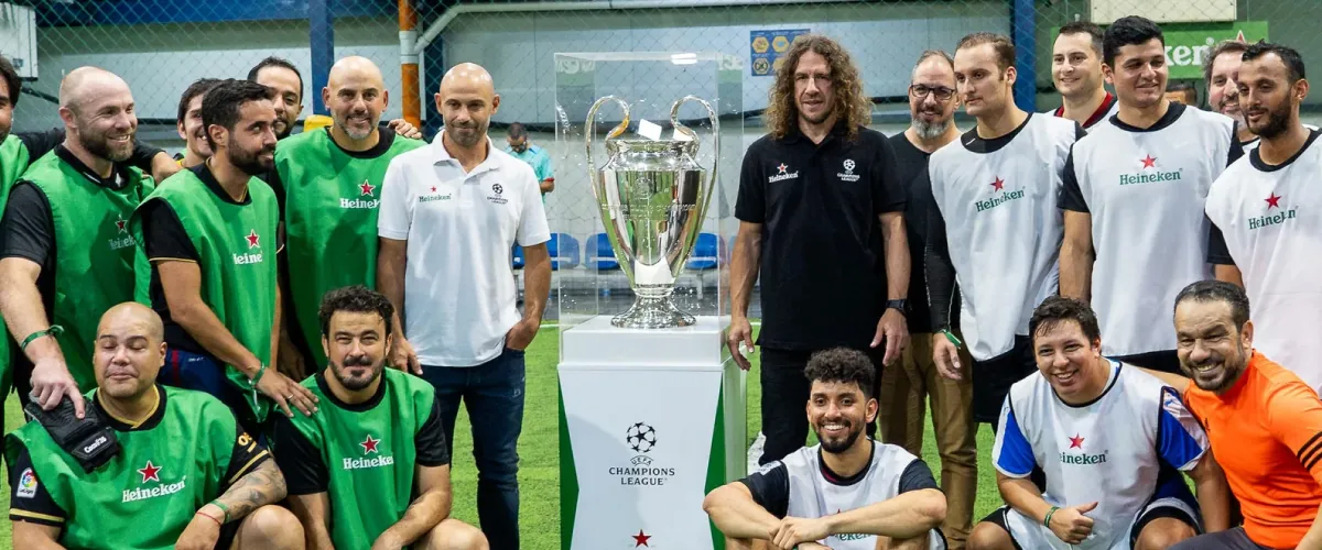 Carles Puyol, Javier Mascherano e invitados junto al trofeo de la Champions League en Fútbol Town