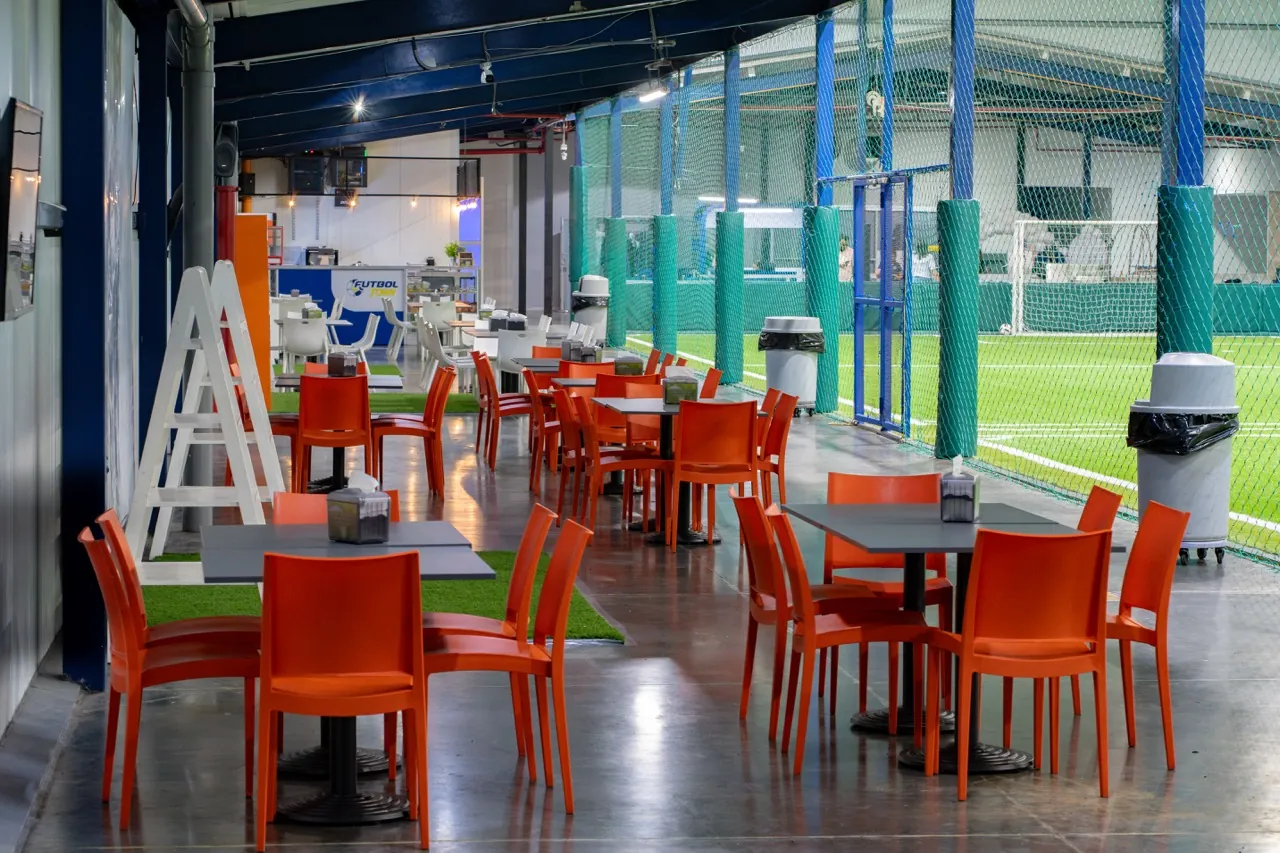 Mesas y sillas de la cafetería junto a las canchas