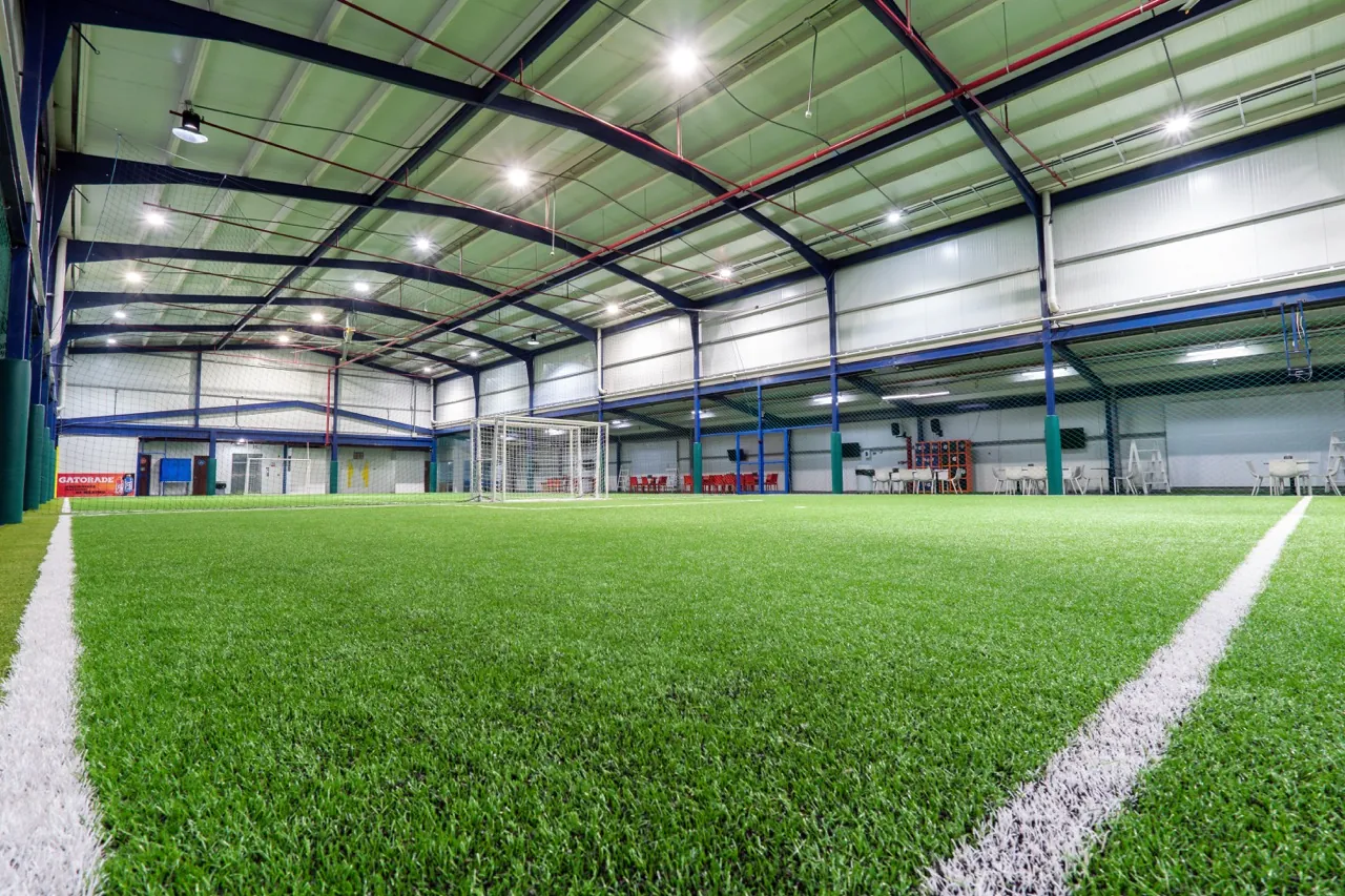 Grama sintética e iluminación de la cancha indoor